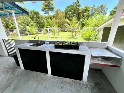 a kitchen sink with a view of a park at Desa Ibol Cottage and River - Max 10Pax