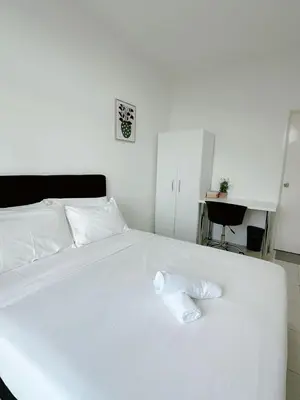 a white bed with a white towel on it at The Anderson Cozy Deluxe Homestay in Ipoh