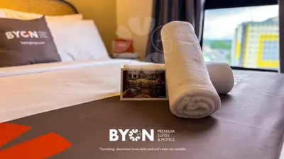 a hotel room with a towel on a bed at Piccadilly Premium Suites Ipoh by BYON in Ipoh