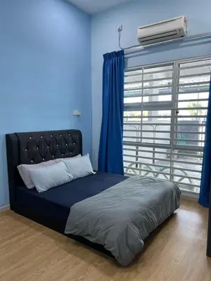 a bedroom with a bed with blue walls and a window at Homestay Anisa Batu Gajah 4 Bilik in Batu Gajah