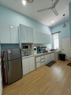 a kitchen with white cabinets and a refrigerator at Homestay Anisa Batu Gajah 4 Bilik in Batu Gajah
