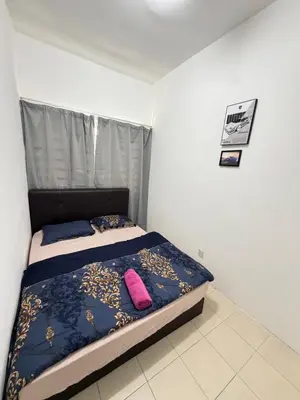 a bedroom with a bed with a blue comforter and pink pillows at AYAAN GAMING ARENA at Tanah Rata Cameron Highland in Tanah Rata