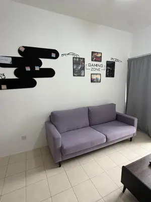 a couch in a living room with a gun on the wall at AYAAN GAMING ARENA at Tanah Rata Cameron Highland in Tanah Rata