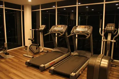 a gym with three cardio machines in a room at Premier Suite at Maritime in George Town