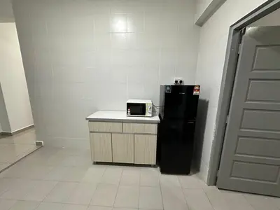 a kitchen with a black refrigerator next to a door at Peace HomestayThe Venus Sitiawan in Sitiawan