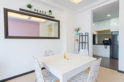 a dining room with a white table and a mirror at Salam Comfy Suite at Bandar Meru Raya Ipoh in Ipoh