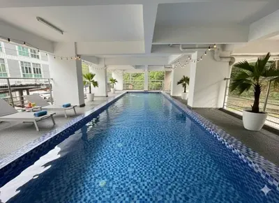 a large swimming pool in a building with a building at Salam Comfy Suite at Bandar Meru Raya Ipoh in Ipoh