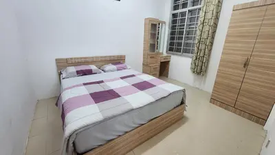 a bedroom with a bed with a purple and white comforter at 9 Storey Apartment Next to Brinchang Centrum Night Market in Cameron Highlands