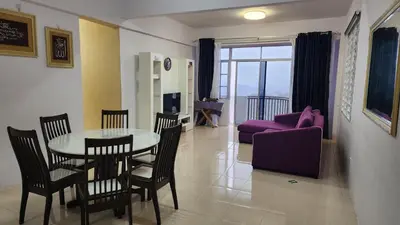 a living room with a table and chairs and a couch at 9 Storey Apartment Next to Brinchang Centrum Night Market in Cameron Highlands