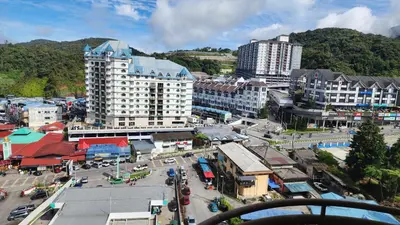 a city with buildings and a street with cars at 9 Storey Apartment Next to Brinchang Centrum Night Market in Cameron Highlands