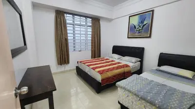 a bedroom with two beds and a table and a window at 9 Storey Apartment Next to Brinchang Centrum Night Market in Cameron Highlands
