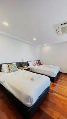 two beds in a room with wooden floors at Sunrise Gurney Georgetwon in George Town