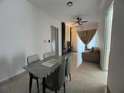 a dining room with a table and chairs and a couch at Icc ipoh y2 homestay in Ipoh