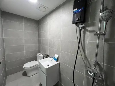 a bathroom with a toilet and a shower and a television at Icc ipoh y2 homestay in Ipoh