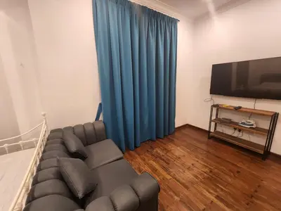 a living room with a couch and a flat screen tv at Gurney Vacation Gathering Comfy Home - Solok Burma in George Town