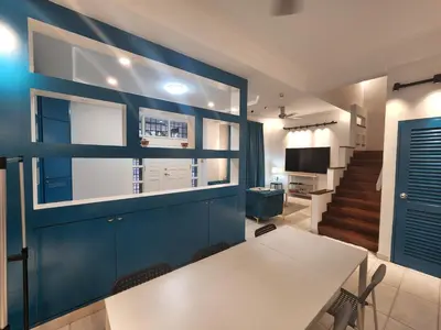 a dining room with a white table and a blue wall at Gurney Vacation Gathering Comfy Home - Solok Burma in George Town