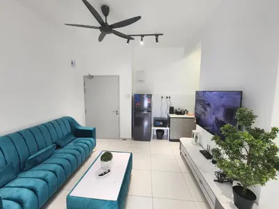 a living room with a blue couch and a tv at Horizon Rooftop Skypool Condotel - Ipoh in Ipoh