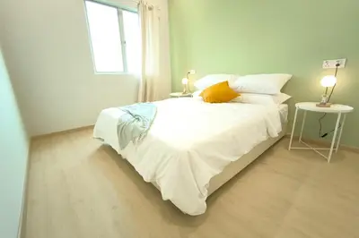 a white bed in a room with a window at Taiping town area - 3 bedroom in Taiping