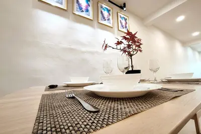 a table with plates and glasses and a plant on it at Taiping town area - 3 bedroom in Taiping