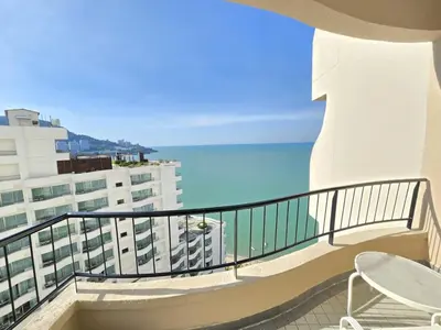 a balcony with a table and a chair and the ocean at Penang Rainbow Paradise in Tanjung Bungah