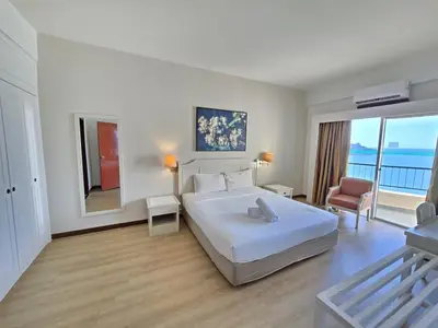 a bedroom with a large white bed and a balcony at Penang Rainbow Paradise in Tanjung Bungah