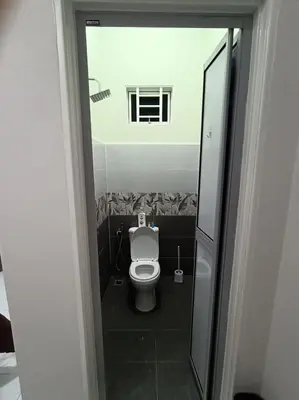 a small bathroom with a toilet and a window at Airisafiq Homestay in Kampong Sungai Rambai