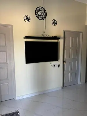 a flat screen tv on a wall in a room at Airisafiq Homestay in Kampong Sungai Rambai