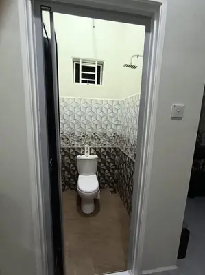 a bathroom with a white toilet in a room at Airisafiq Homestay in Kampong Sungai Rambai
