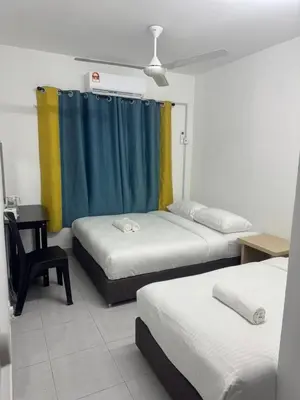 a room with three beds and a blue curtain at Raub Colonial Homestay in Raub