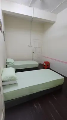 a room with two beds and a red suitcase at Affordable Nice and Comfortable Room in George Town