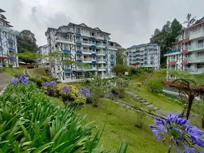 a garden with flowers in front of buildings at PAS Homstay CH 2026 in Tanah Rata