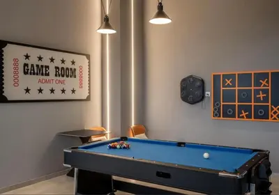 a room with a pool table and a clock at Wanderlust Retreat 1R by Iconic Regency in Bayan Lepas