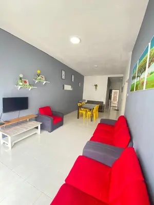 a living room with red furniture and a dining room at Rayyan'Homestay JAYA in Tanah Rata