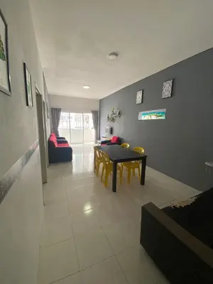 a living room with a table and a couch at Rayyan'Homestay JAYA in Tanah Rata