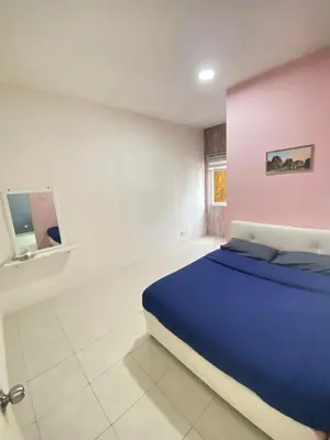 a bedroom with a blue bed and a pink wall at Rayyan'Homestay JAYA in Tanah Rata