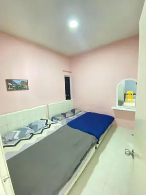 a bedroom with two beds in a pink room at Rayyan'Homestay JAYA in Tanah Rata