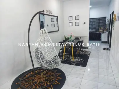 a hanging chair in a room with a table at Naryan Homestay Teluk Batik in Lumut