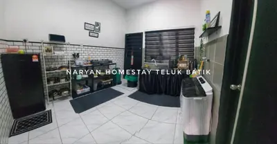 a room with a kitchen with a table with a bottle of wine at Naryan Homestay Teluk Batik in Lumut