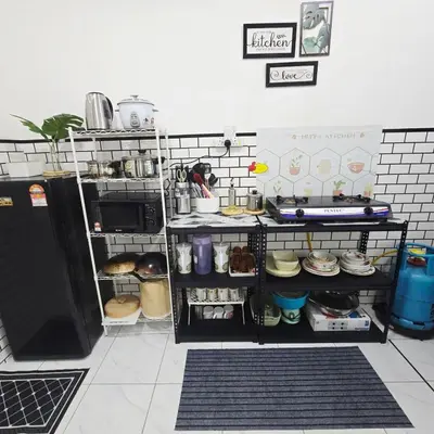 a kitchen with a refrigerator and shelves with food at Naryan Homestay Teluk Batik in Lumut
