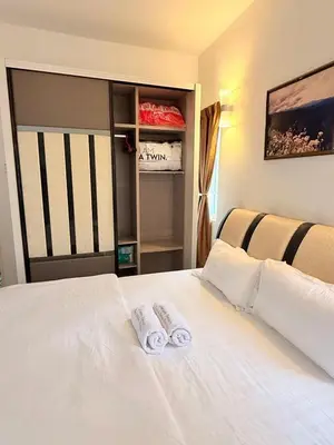 a bedroom with a white bed with towels on it at The Nest Retreat, B7-3A-1 2BR Family Suite in Bukit Fraser