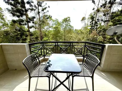 a table and two chairs sitting on a balcony at The Nest Retreat, B7-3A-1 2BR Family Suite in Bukit Fraser