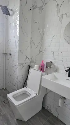 a white bathroom with a toilet and a sink at Seri Ipoh in Ipoh