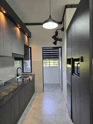 a kitchen with stainless steel cabinets and a hallway at Seri Ipoh in Ipoh