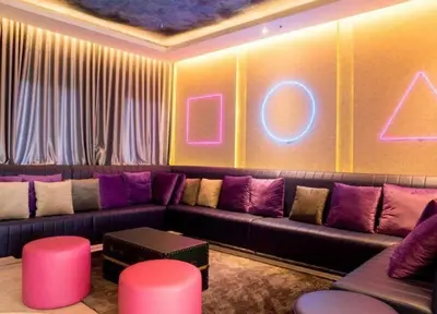 a living room with a couch and neon signs on the wall at Seri Ipoh in Ipoh