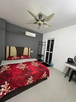 a bedroom with a red bed with a ceiling fan at Classic Pearl Homestay in Teluk Intan