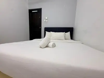 a large white bed in a white room at Austin Taman Daya Large Corner House for 10 Pax in Gua Sai