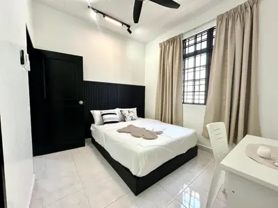 a bedroom with a bed with a black headboard at Spacious Classic 4BR Family Haven I Simpang Ampat in Simpang Ampat