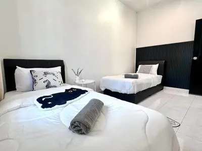 a bedroom with two beds with towels on them at Spacious Classic 4BR Family Haven I Simpang Ampat in Simpang Ampat