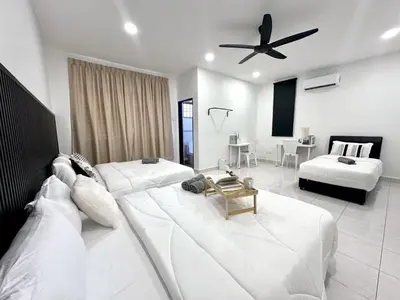 a living room with a large white couch and a bed at Spacious Classic 4BR Family Haven I Simpang Ampat in Simpang Ampat