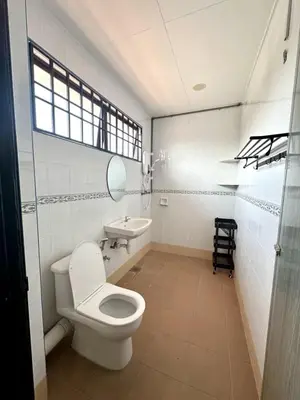 a bathroom with a white toilet and a sink at Spacious Classic 4BR Family Haven I Simpang Ampat in Simpang Ampat